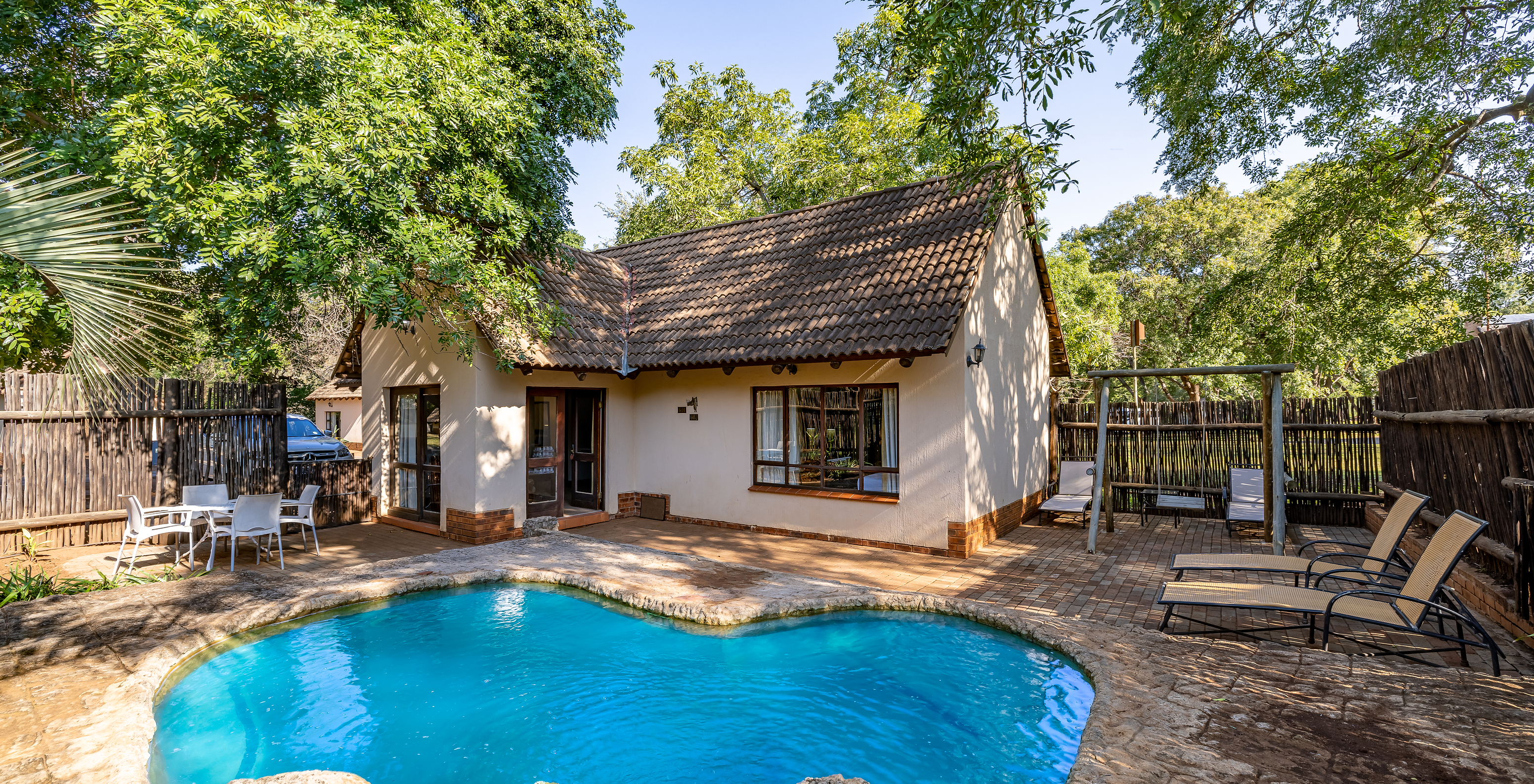 Le Rhino Family Cottage du Pestana Kruger Lodge a une piscine privée avec chaises longues près de la chambre