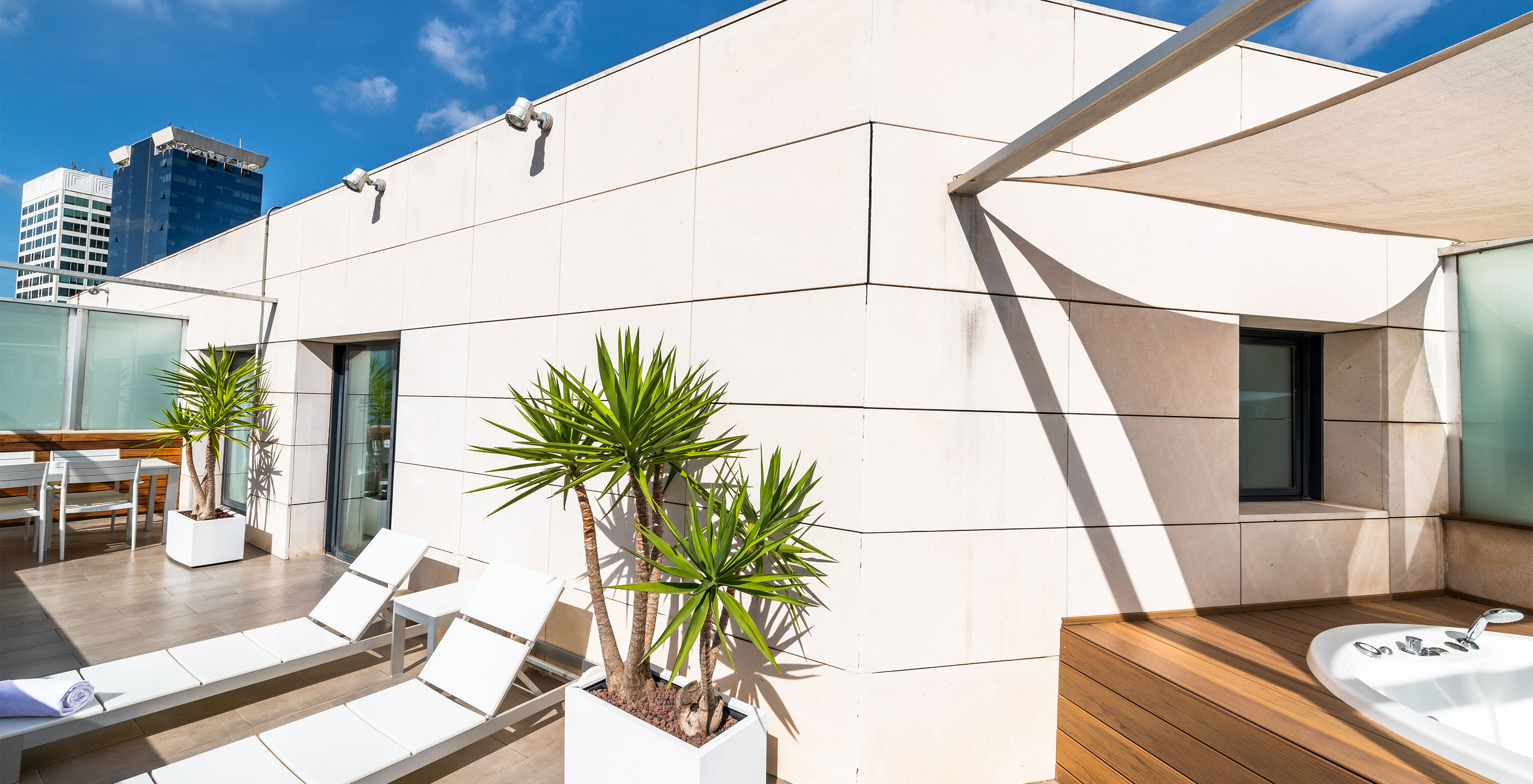 La Junior Suite du Pestana Arena Barcelona a une terrasse sur le toit avec chaises longues et jacuzzi pour se détendre.