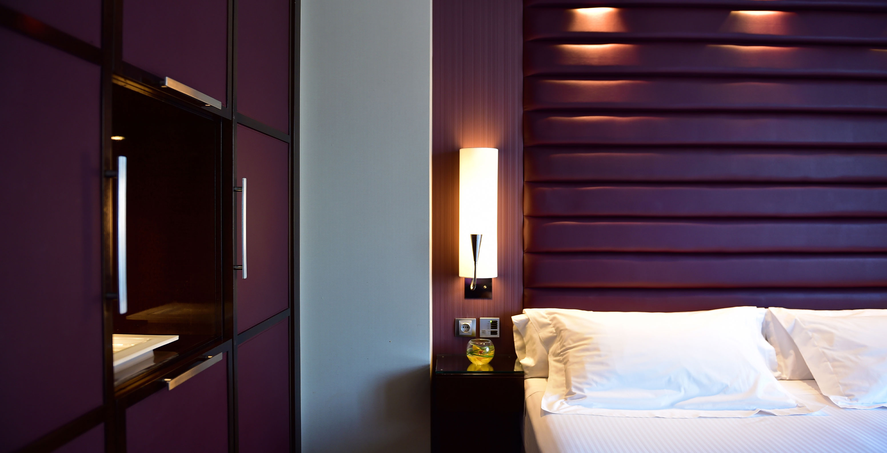 La chambre Standard Twin du Pestana Arena Barcelona a une décoration moderne en violet, un lit double et un placard