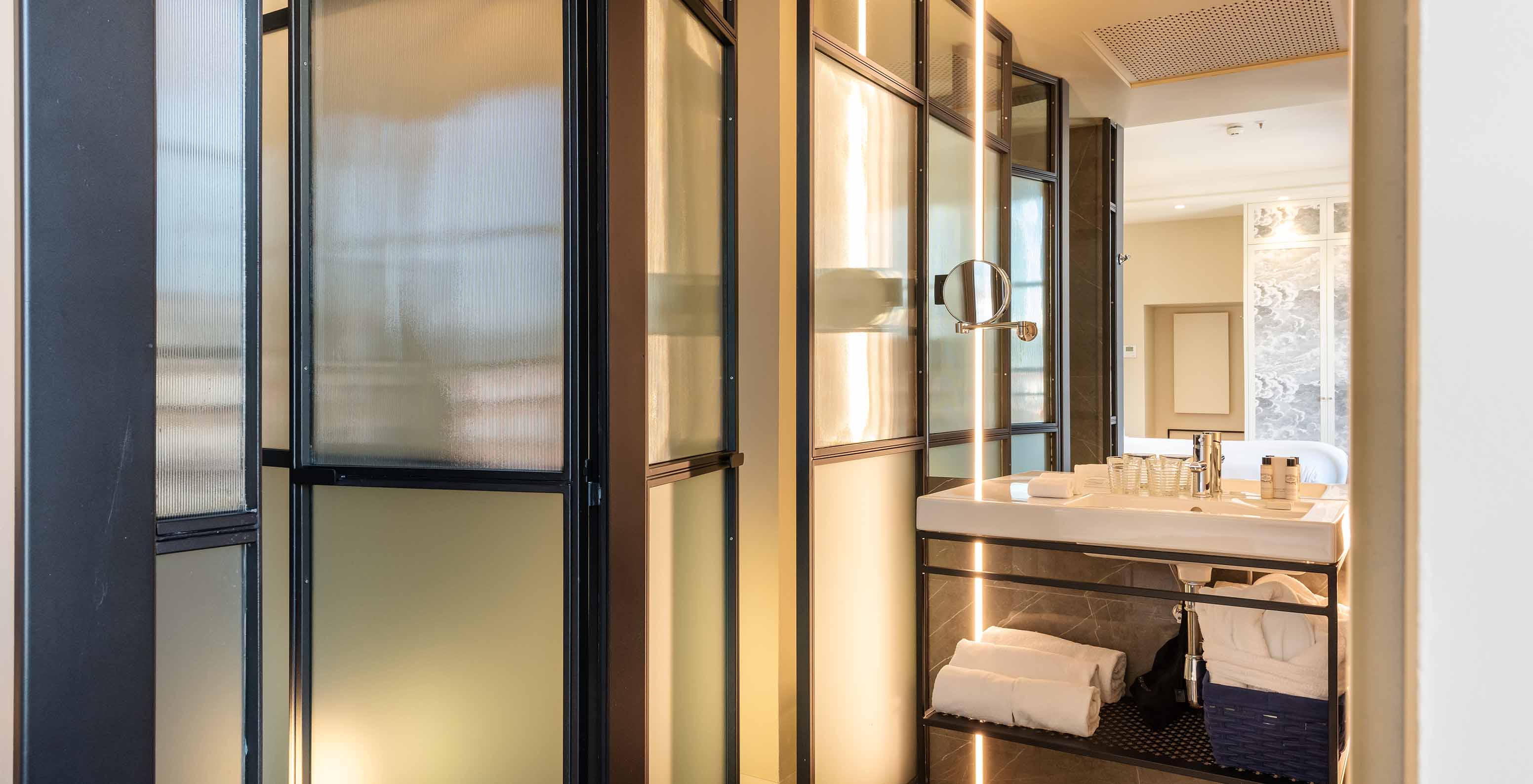 Le Deluxe Grand Plaza Mayor du Pestana Plaza Mayor Madrid a une salle de bain avec lavabo, miroir et serviettes