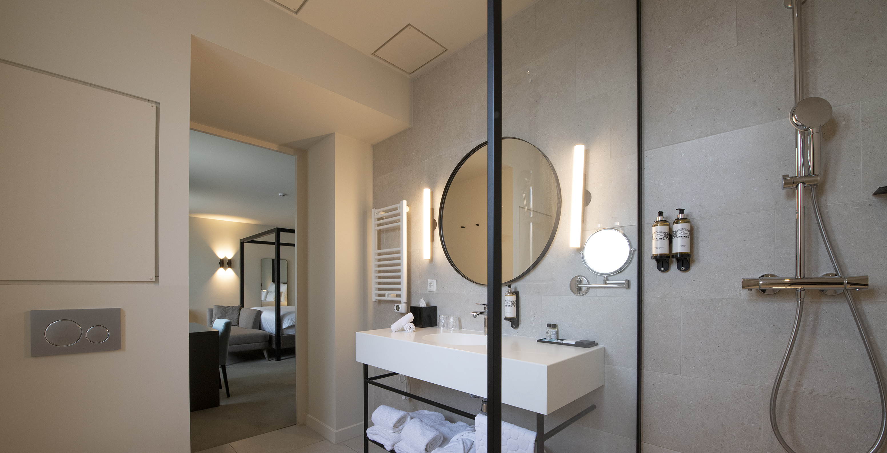 La chambre Premium Deluxe du Pestana Amsterdam Riverside a une salle de bain avec miroir, lavabo, serviettes et douche