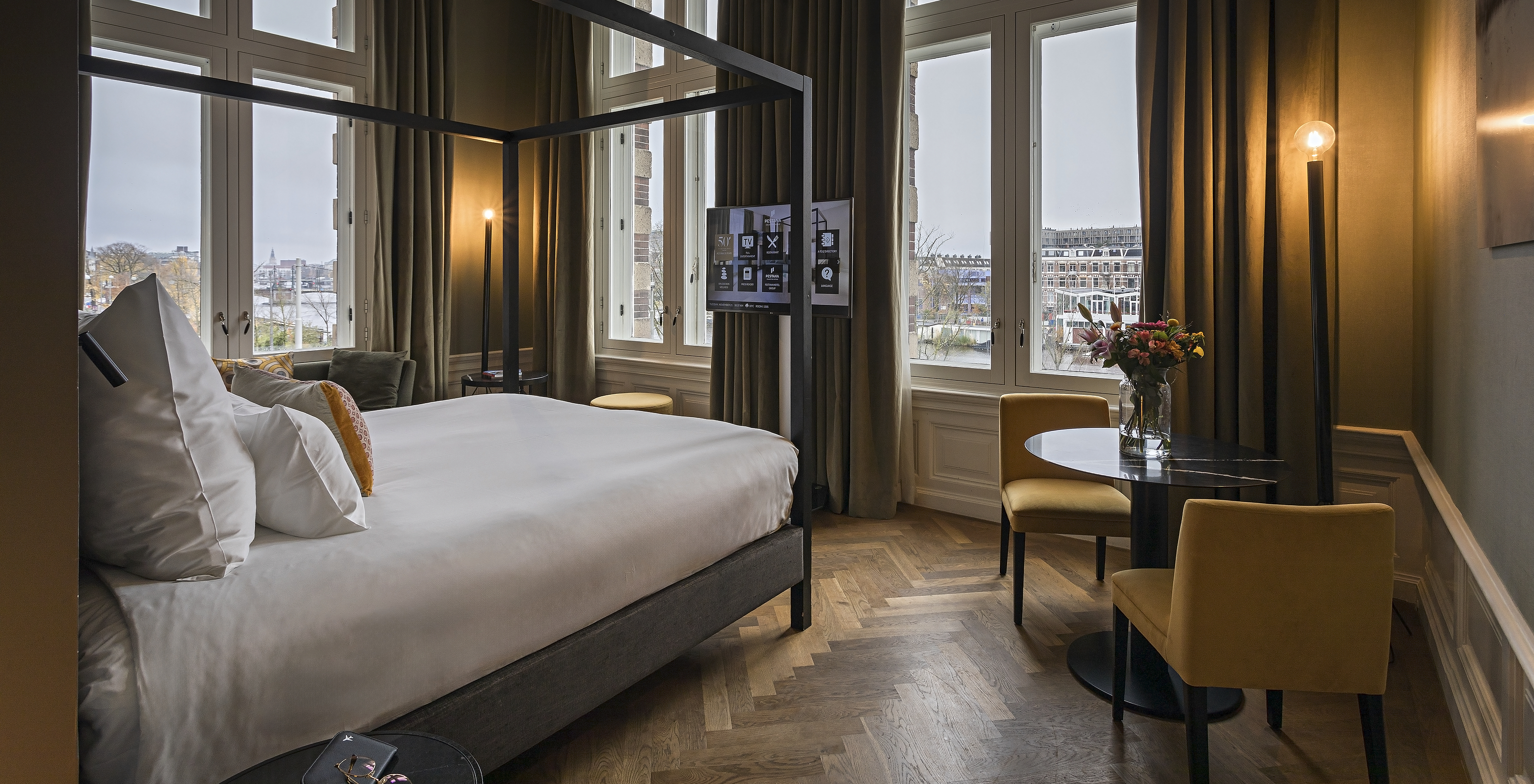 La Presidential Suite - Vue Rivière du Pestana Amsterdam Riverside a un lit double avec baldaquin et télévision