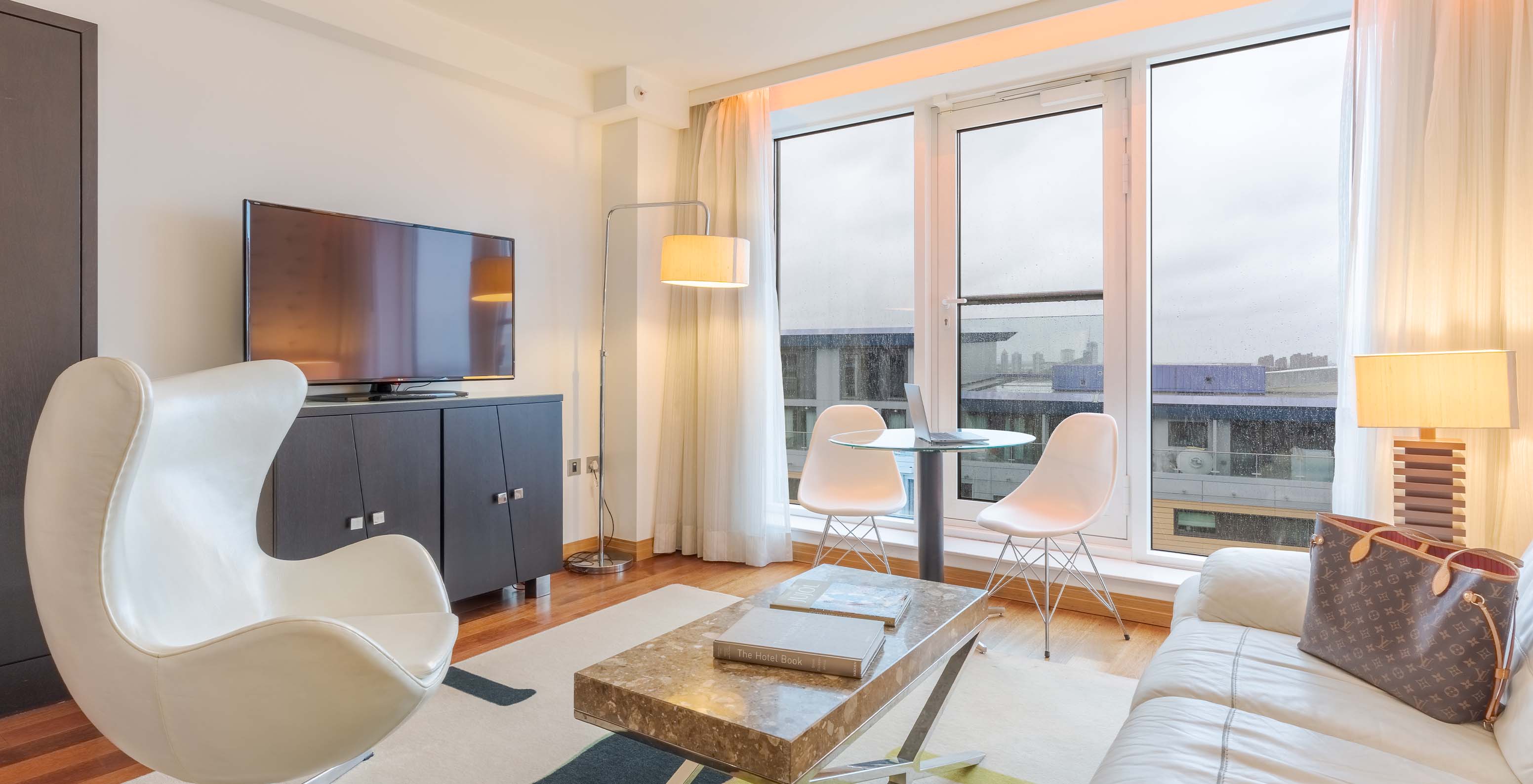 La Suite Exécutive 1 Chambre du Pestana Chelsea Bridge a un salon avec canapé, table basse, télévision et fenêtres