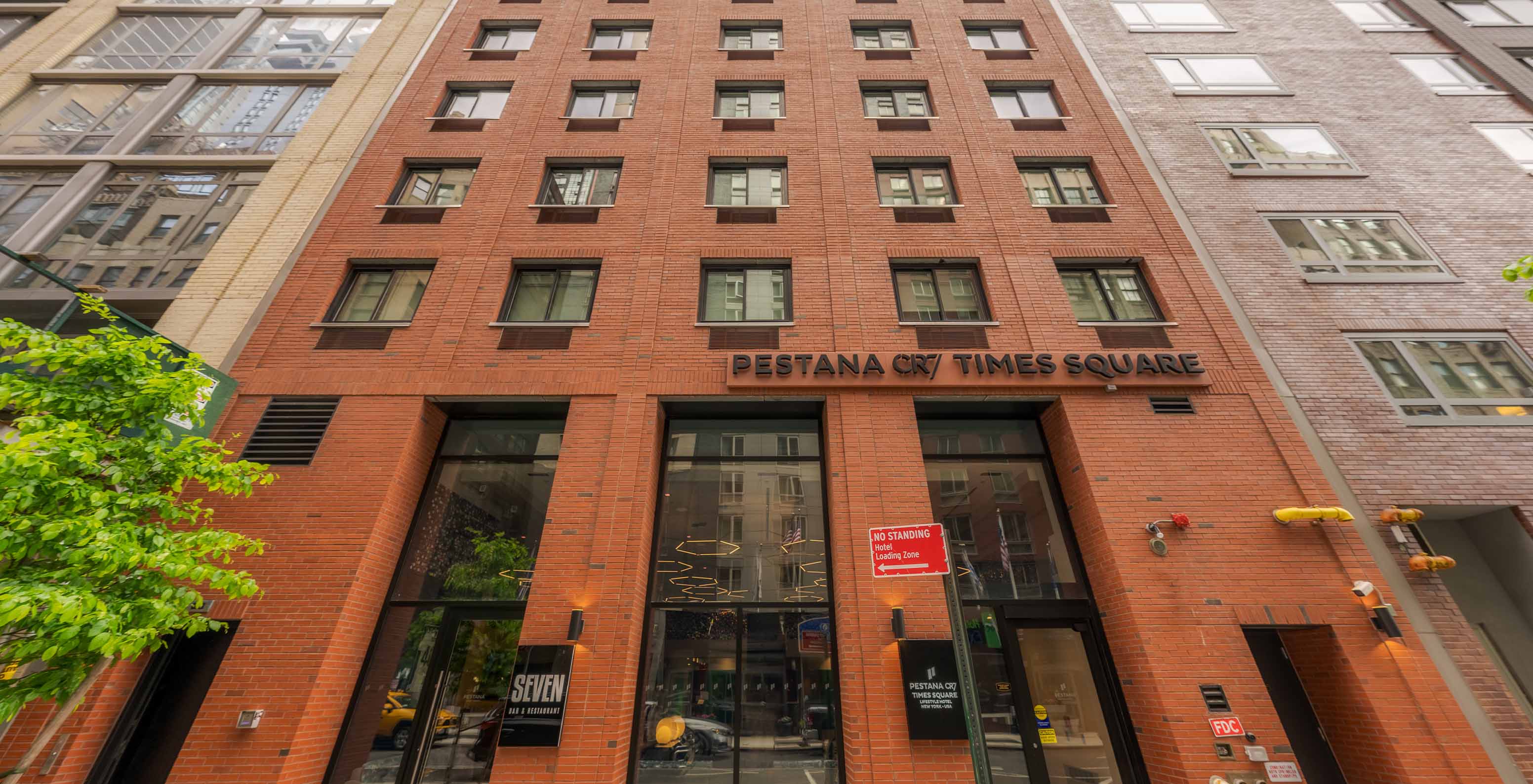 Façade du Pestana CR7 Times Square, en briques orange, avec plusieurs fenêtres carrées