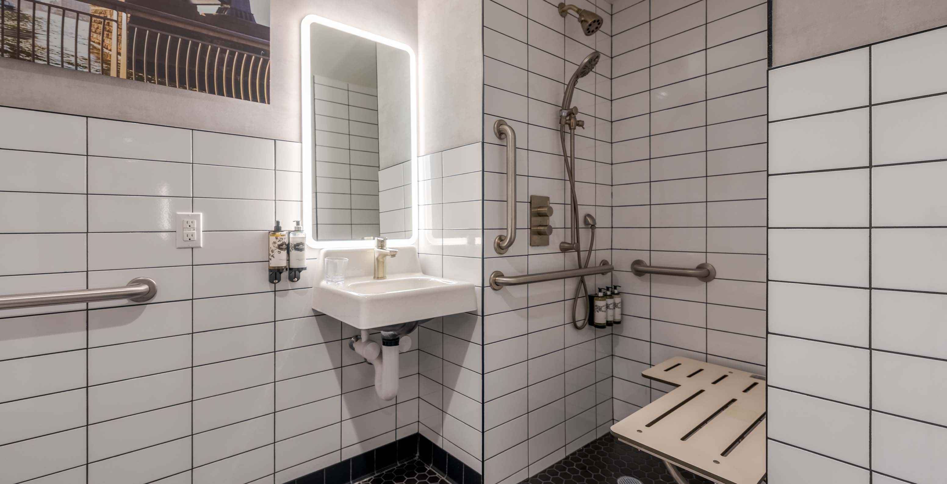 Le Comfort ADA du Pestana CR7 Times Square a une salle de bain adaptée avec douche, lavabo et miroir