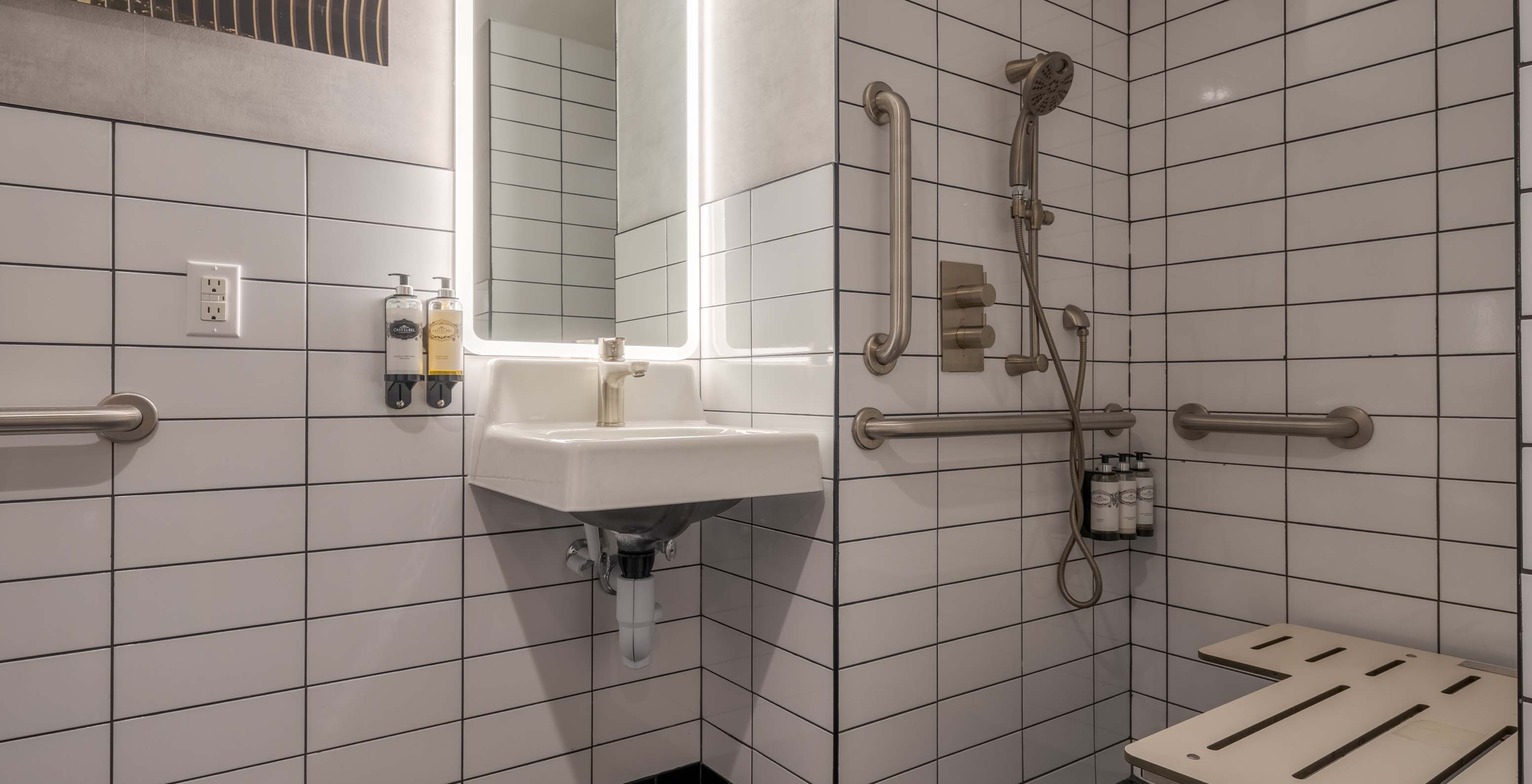 Le Comfort Street View ADA du Pestana CR7 Times Square a une salle de bain adaptée avec douche, lavabo et miroir