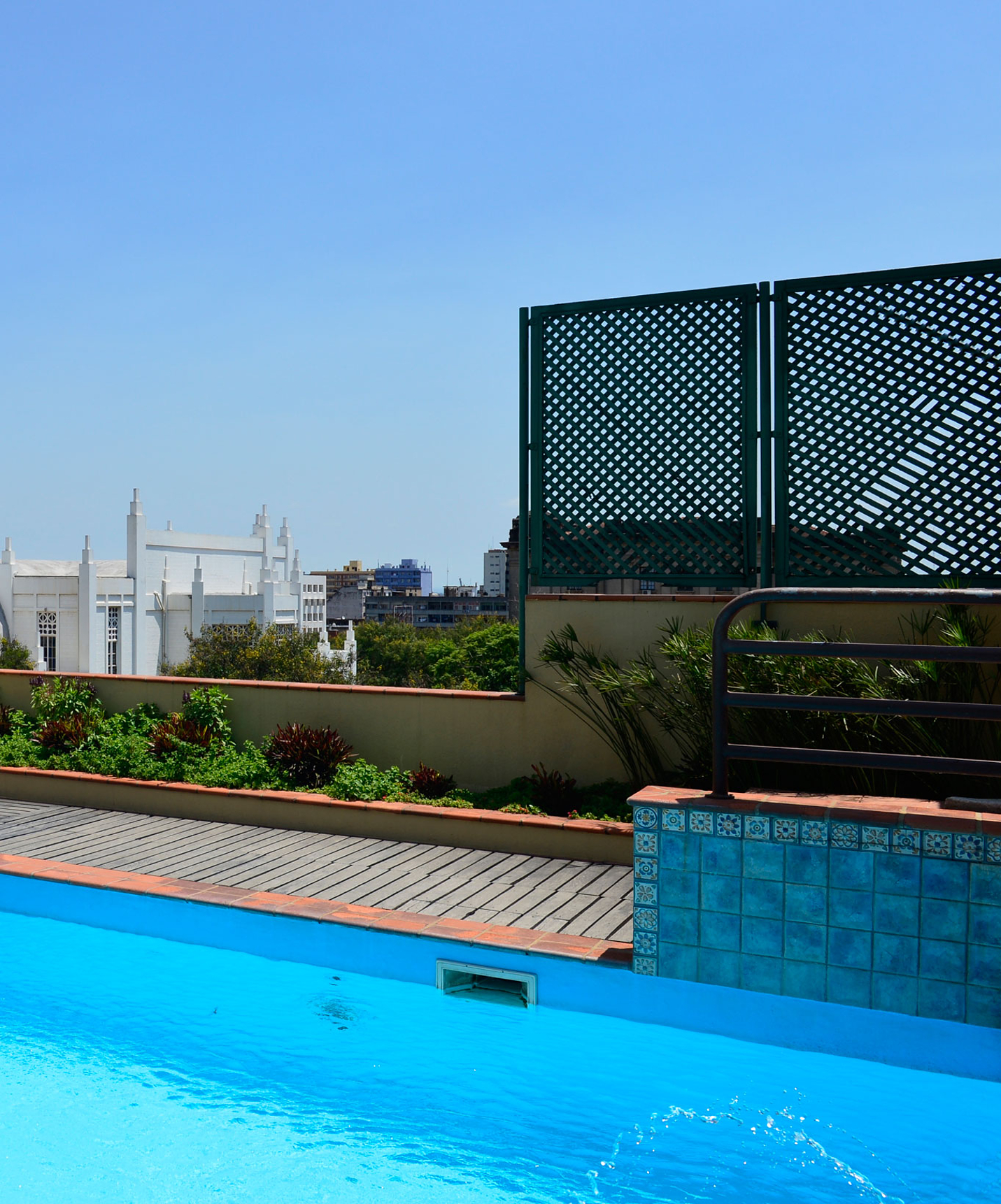 Rooftop met buitenzwembad, tafels en uitzicht op kathedraal in hotel in centrum van Maputo