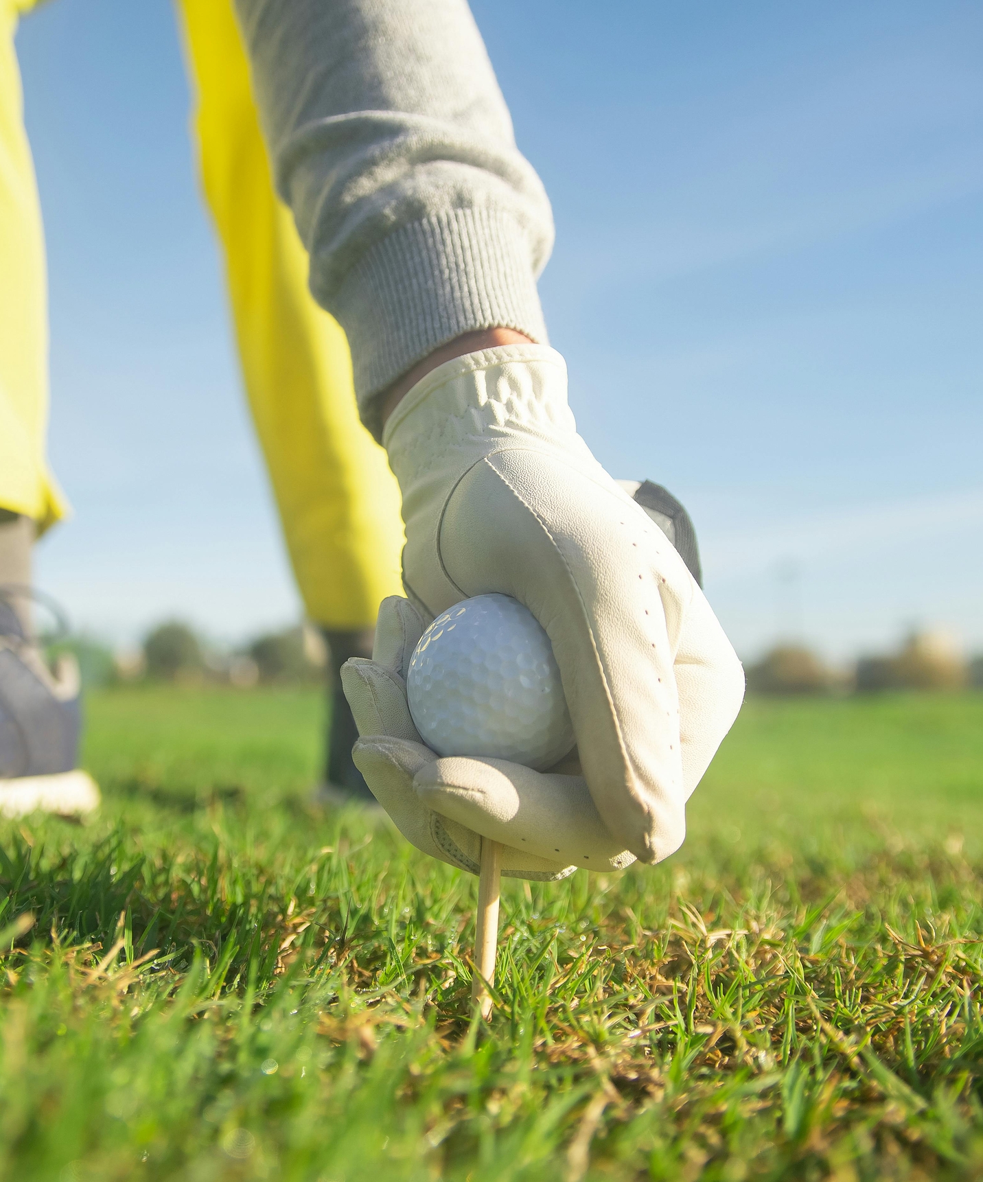 Man neemt golfbal en bereidt zich voor op volgende slag in hotel met zwembad op een golfbaan