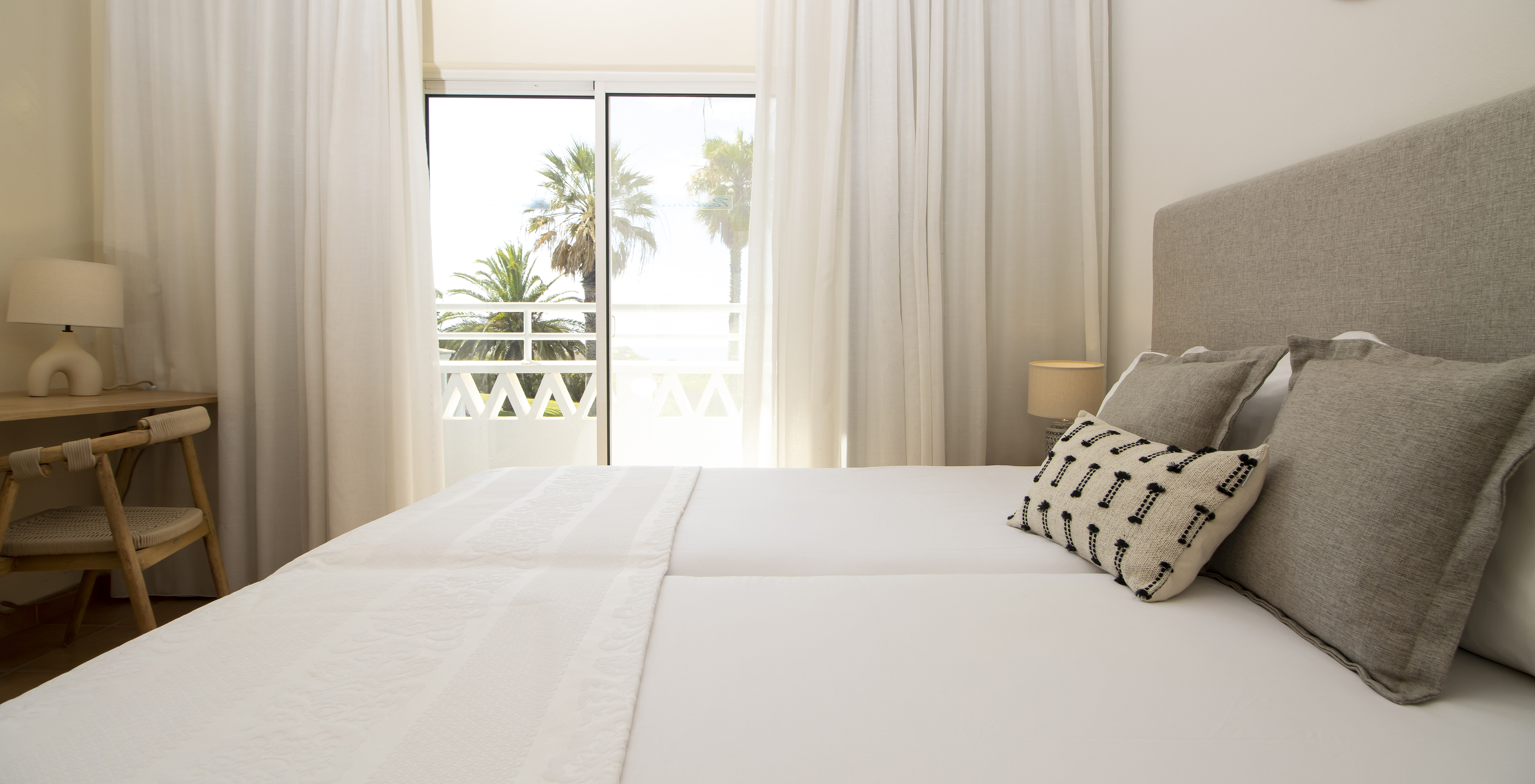 Het Appartement T2 Superior van Pestana Palm Gardens heeft een bed met kussens, een raam dat toegang geeft tot een balkon