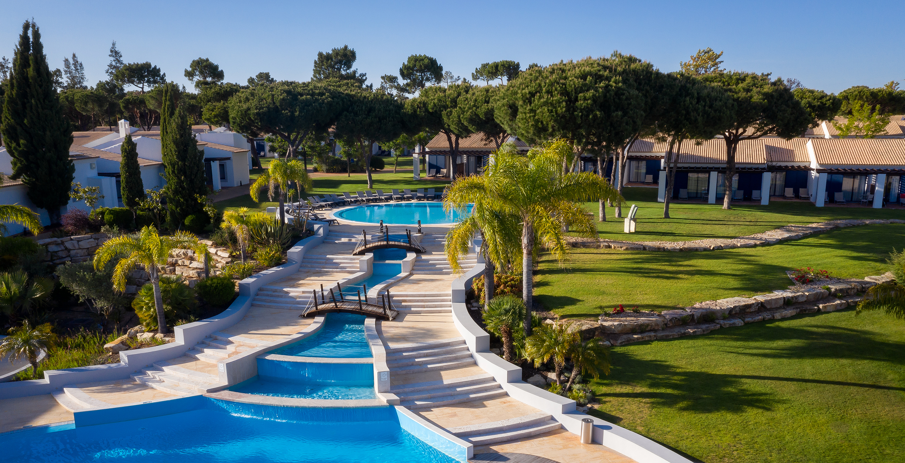 Buiten zwembad en ligstoelen, omgeven door groen bij Pestana Vila Sol - Vilamoura, Hotel met Golf en Spa in de Algarve