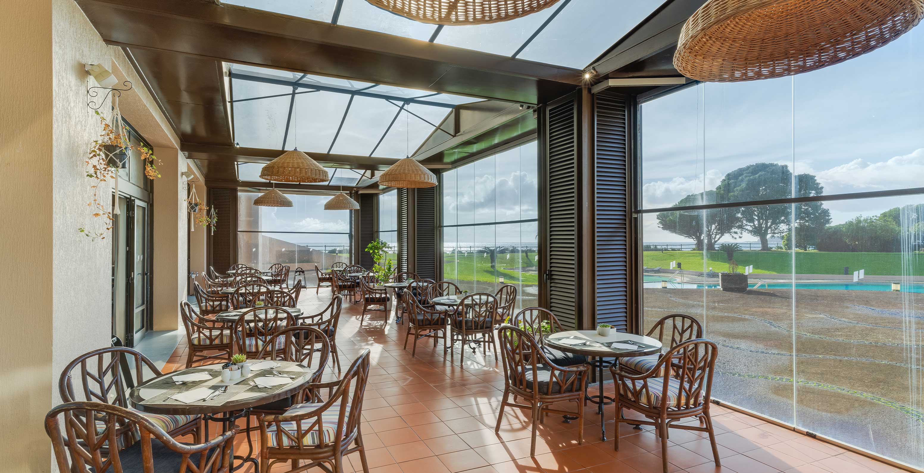 Het restaurant Lugar da Praia, van het 4-sterrenhotel op de Azoren, heeft een overdekt terras met uitzicht op het zwembad