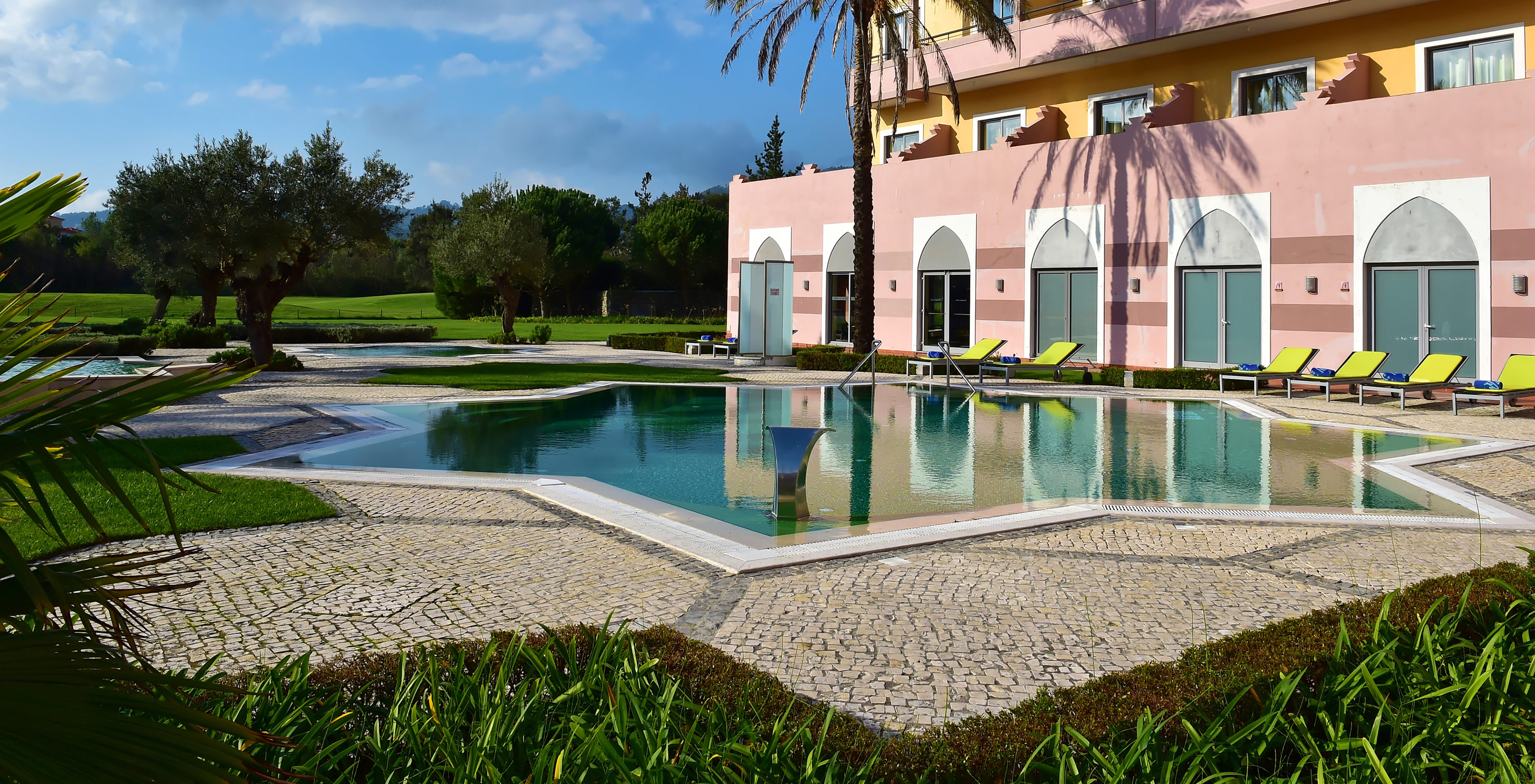 Buitenzwembad op een zonnige dag, met palmbomen en ligstoelen in Pestana Sintra Golf, hotel met golf en spa in Sintra