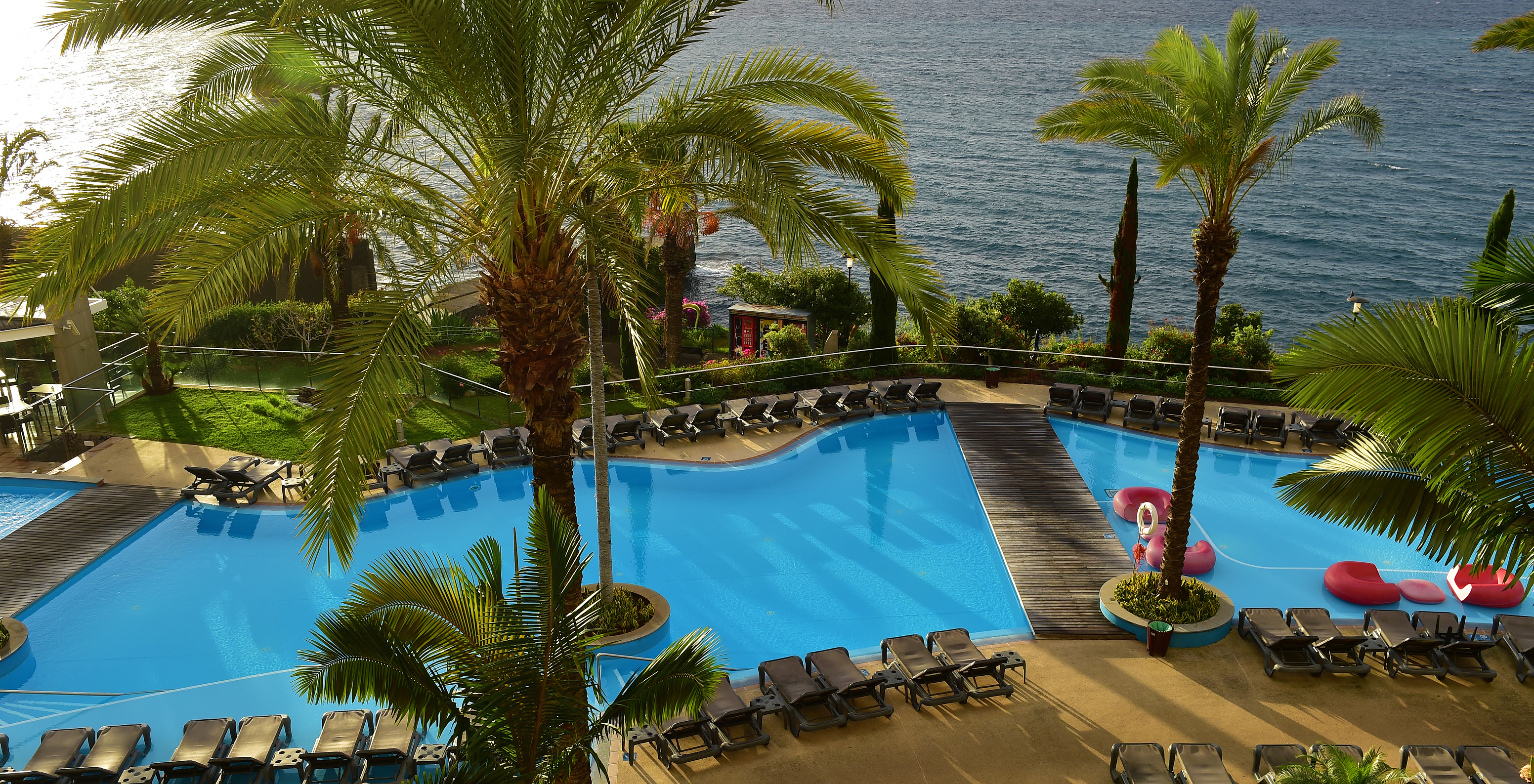 Pestana Promenade op Madeira met buitenzwembad en ligstoelen met uitzicht op zee