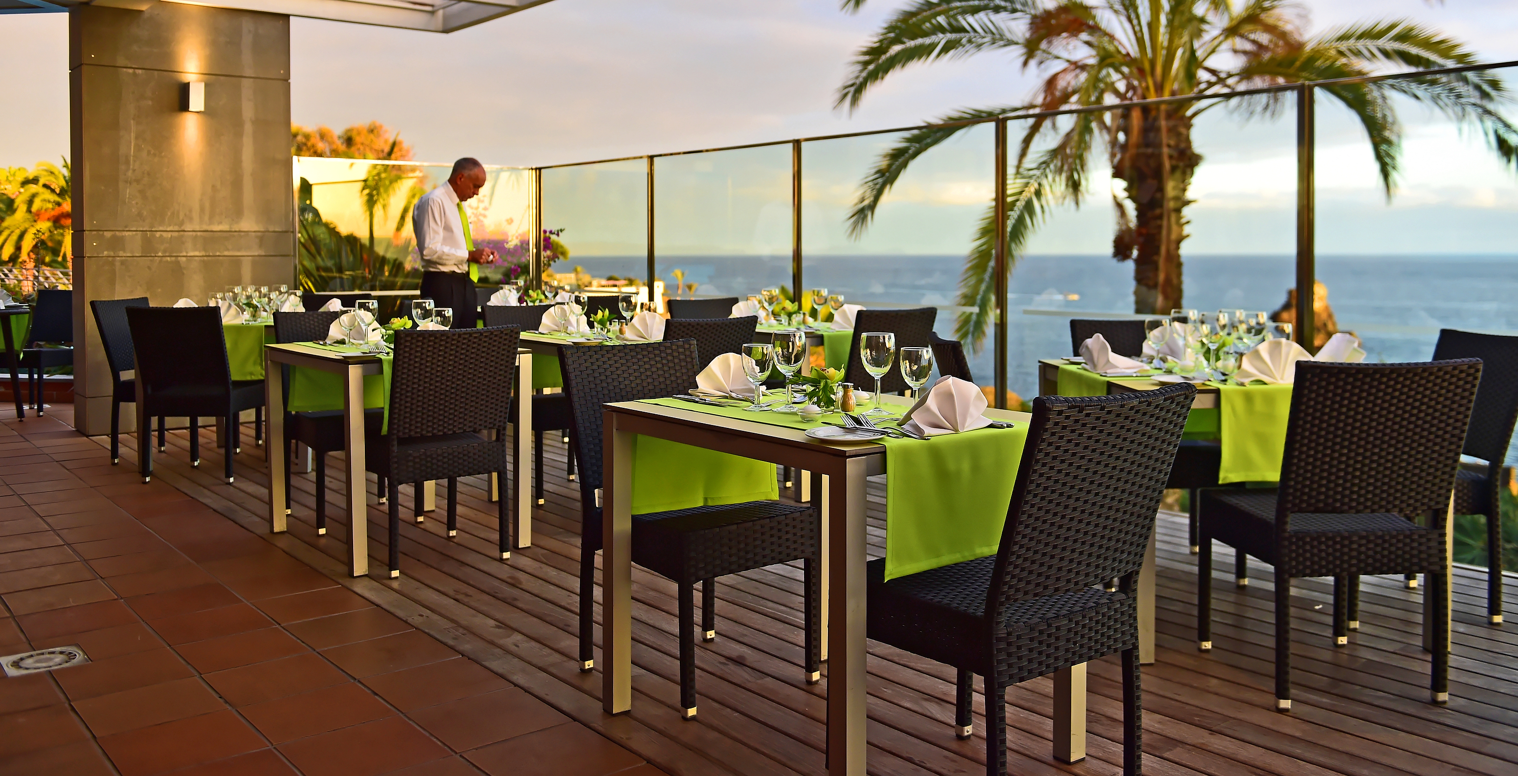 Het restaurant The Deck, van het 4-sterrenhotel aan zee in Funchal, heeft een ronde tafel met rode stoelen