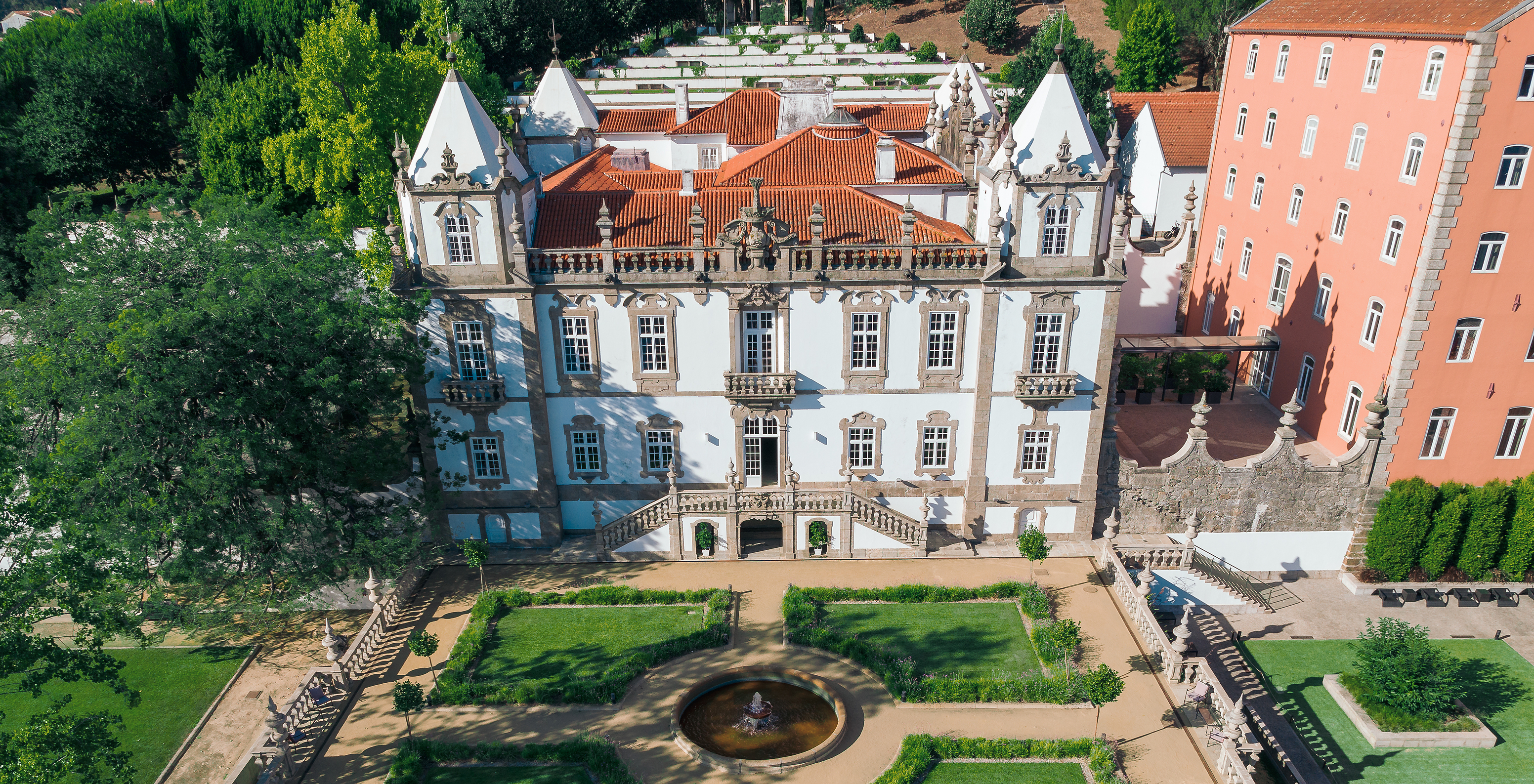 Gevel van Pestana Palácio do Freixo overdag, een imposant paleis met een goed onderhouden tuin eromheen