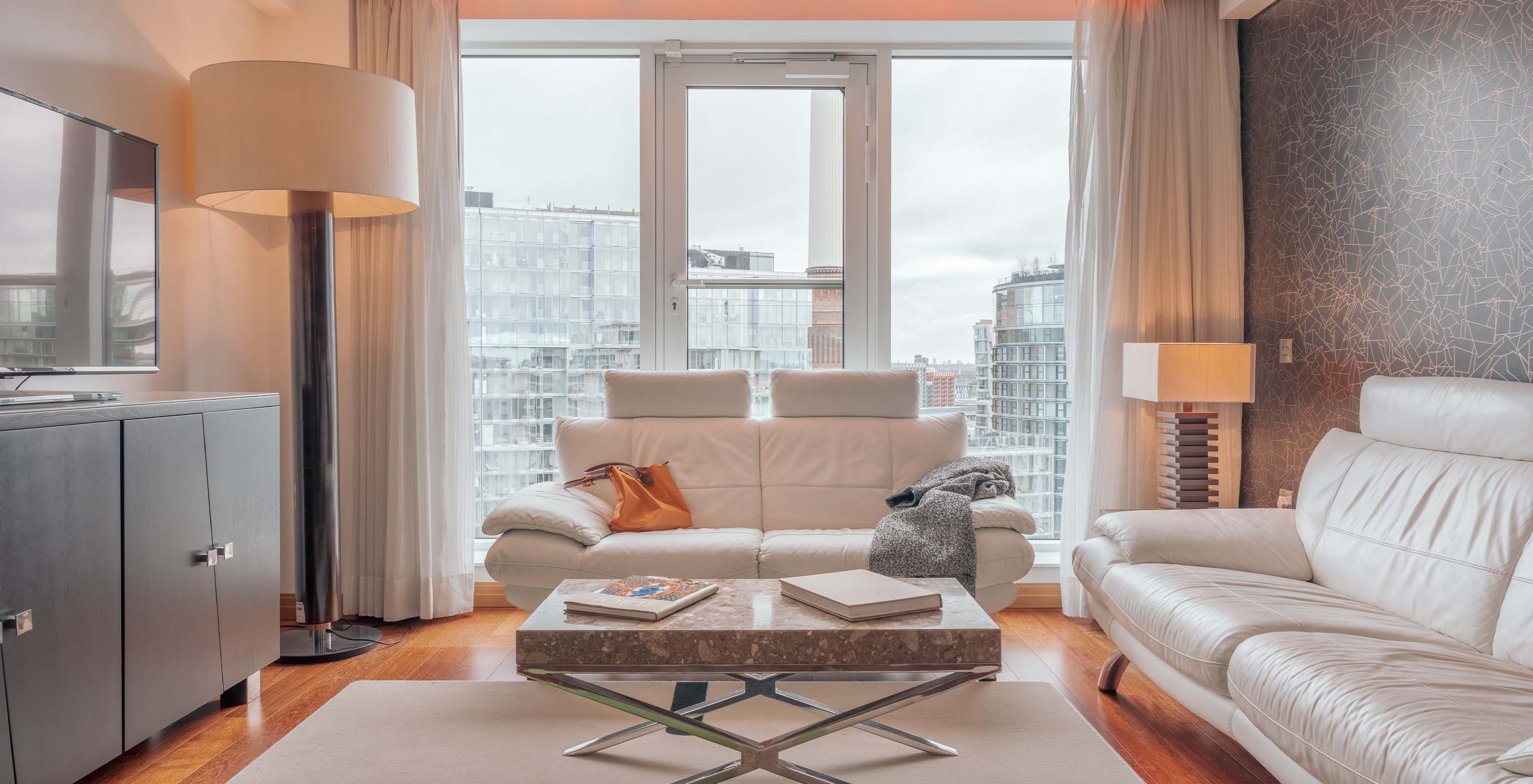 De Signature Suite met 2 Slaapkamers van Pestana Chelsea Bridge heeft een woonkamer met bank, salontafel, televisie en ramen