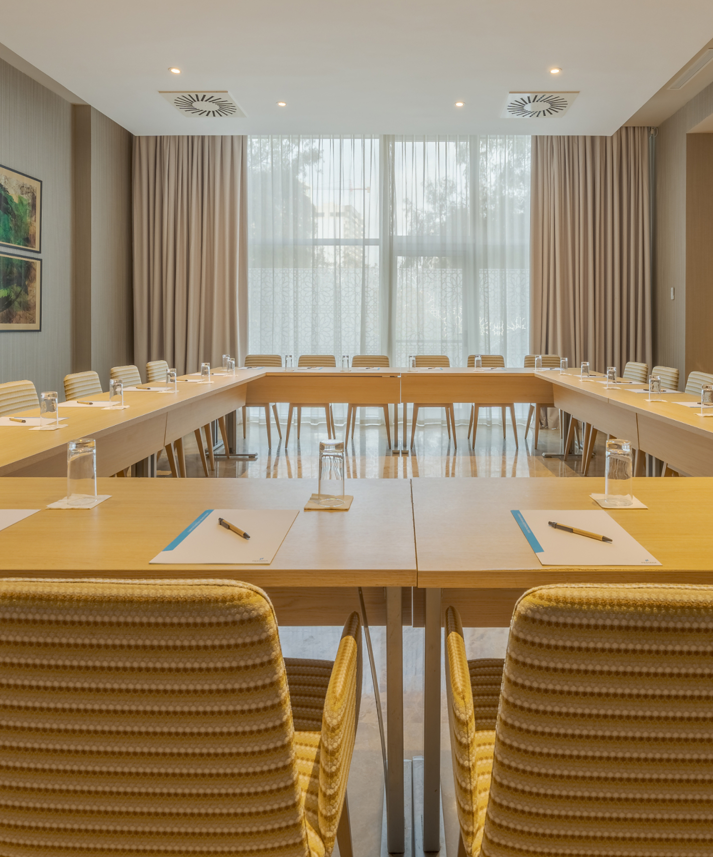 Sala de reuniões do Pestana Tanger City Center, Hotel em Tânger Perto da Praia, com cadeiras amarelas e janelas grandes