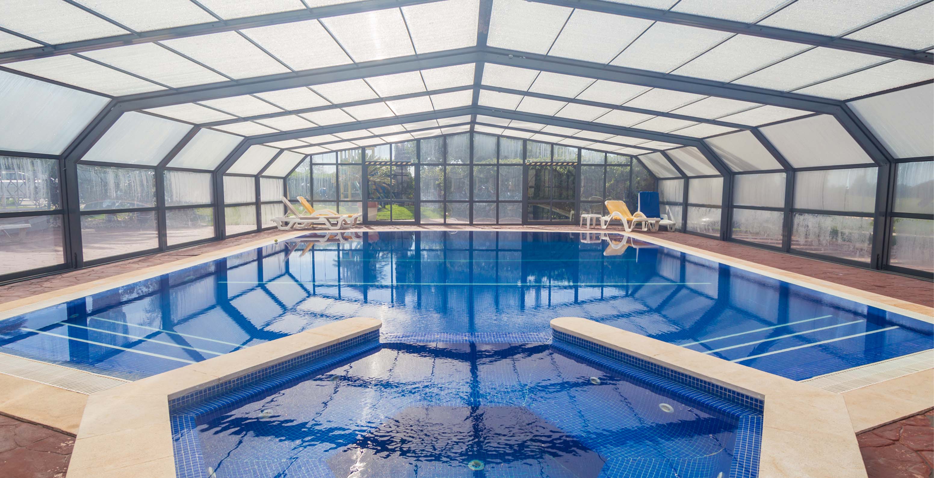 Piscina interior do Pestana Carvoeiro, hotel no Carvoeiro perto de Campos de Golfe, com acesso ao jardim