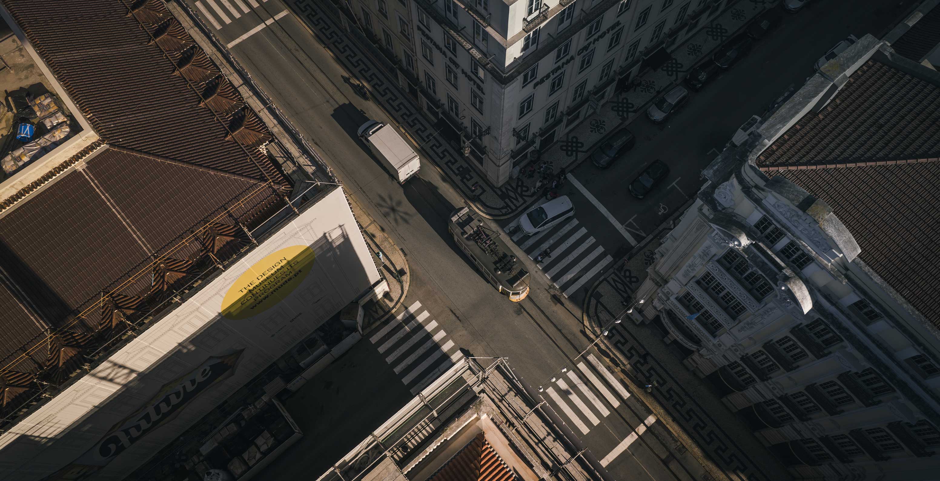 Cruzamento na zona histórica de Lisboa, visto de cima, onde o elétrico 28 faz a sua travessia