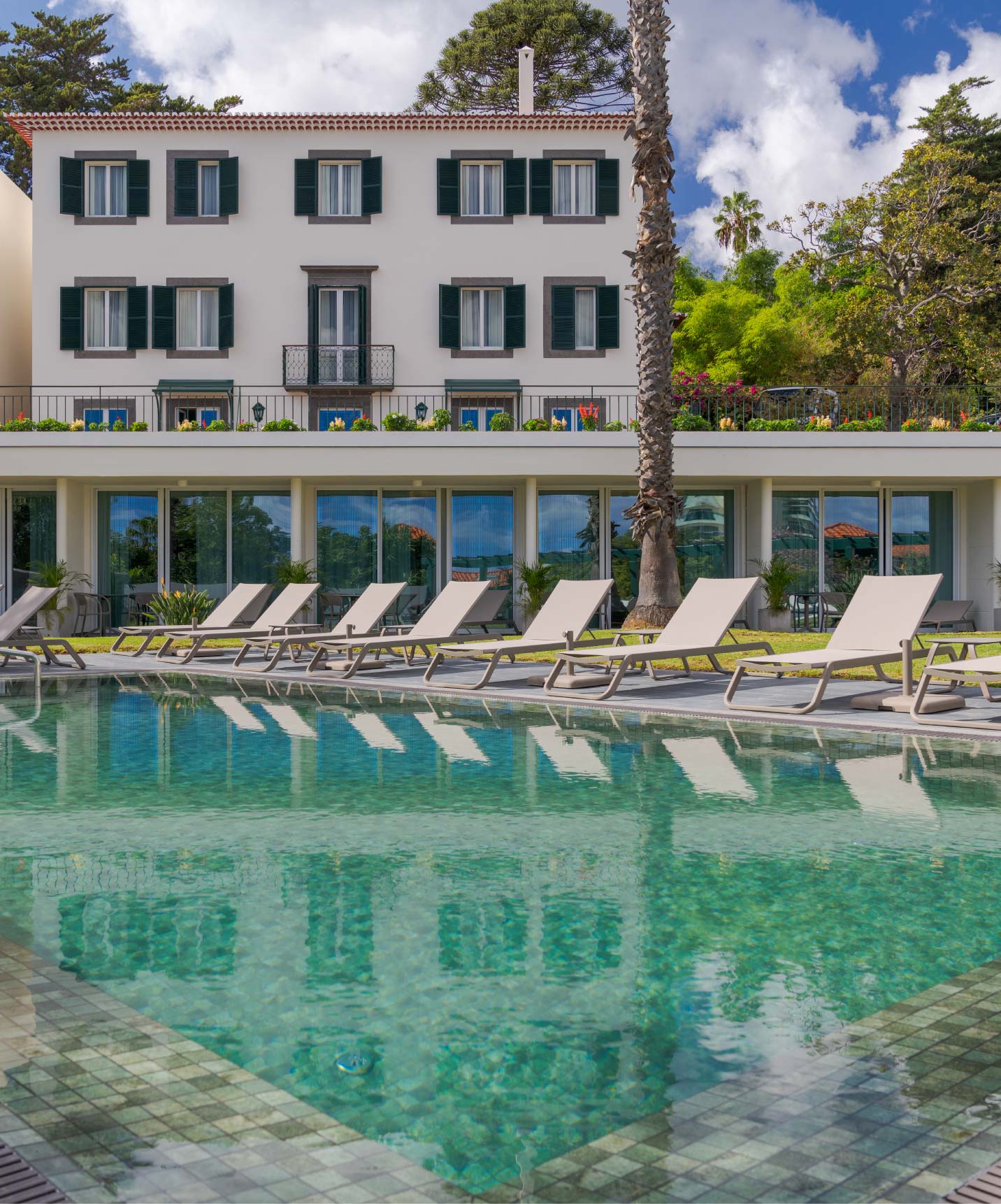 Vista da piscina exterior do Pestana Quinta Perestrello, um Hotel de Charme na Madeira, com o edifício atrás