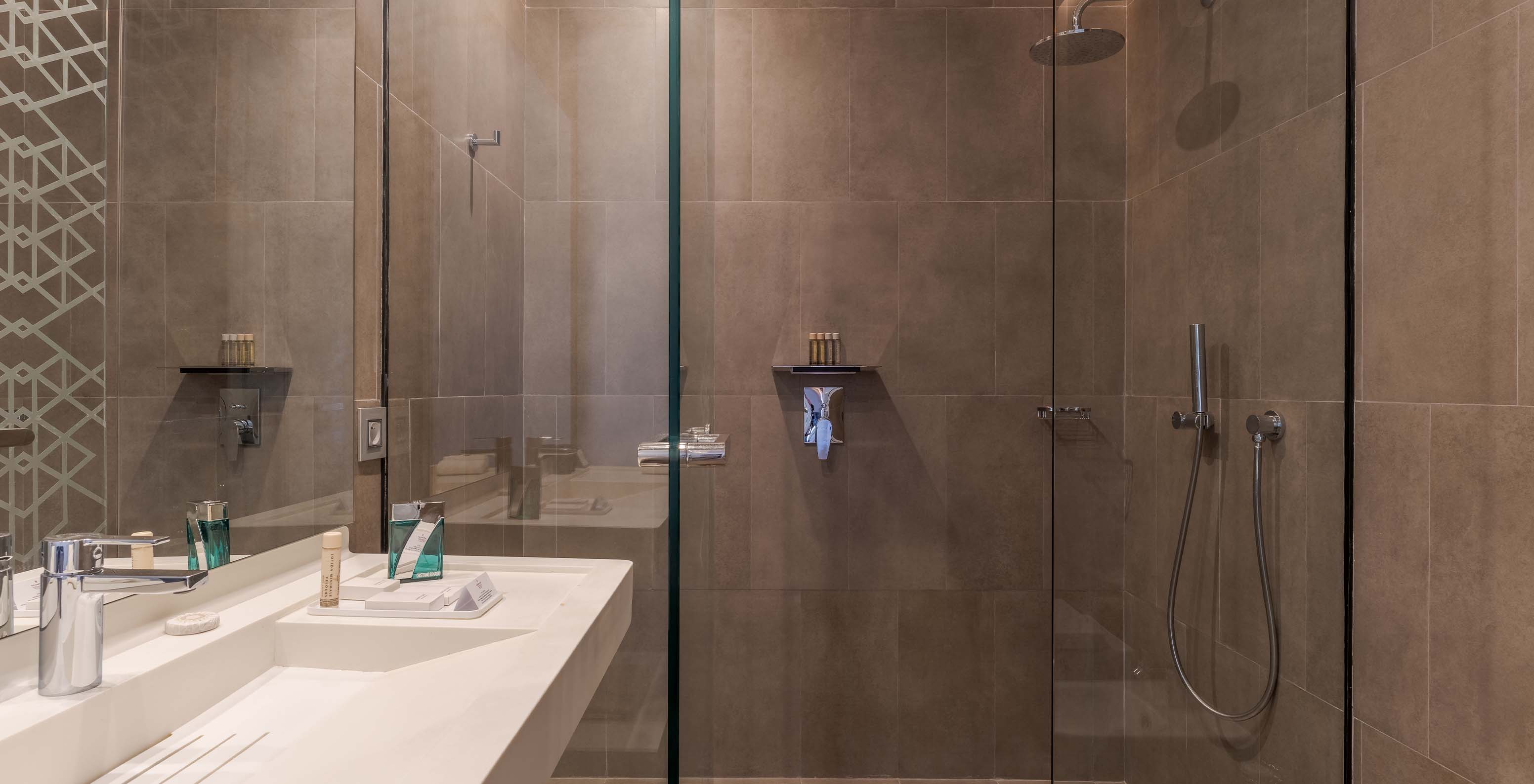 O CR7 Superior Avenue do Pestana CR7 Marrakech tem uma casa de banho com walk-in shower e lavatório com um espelho grande