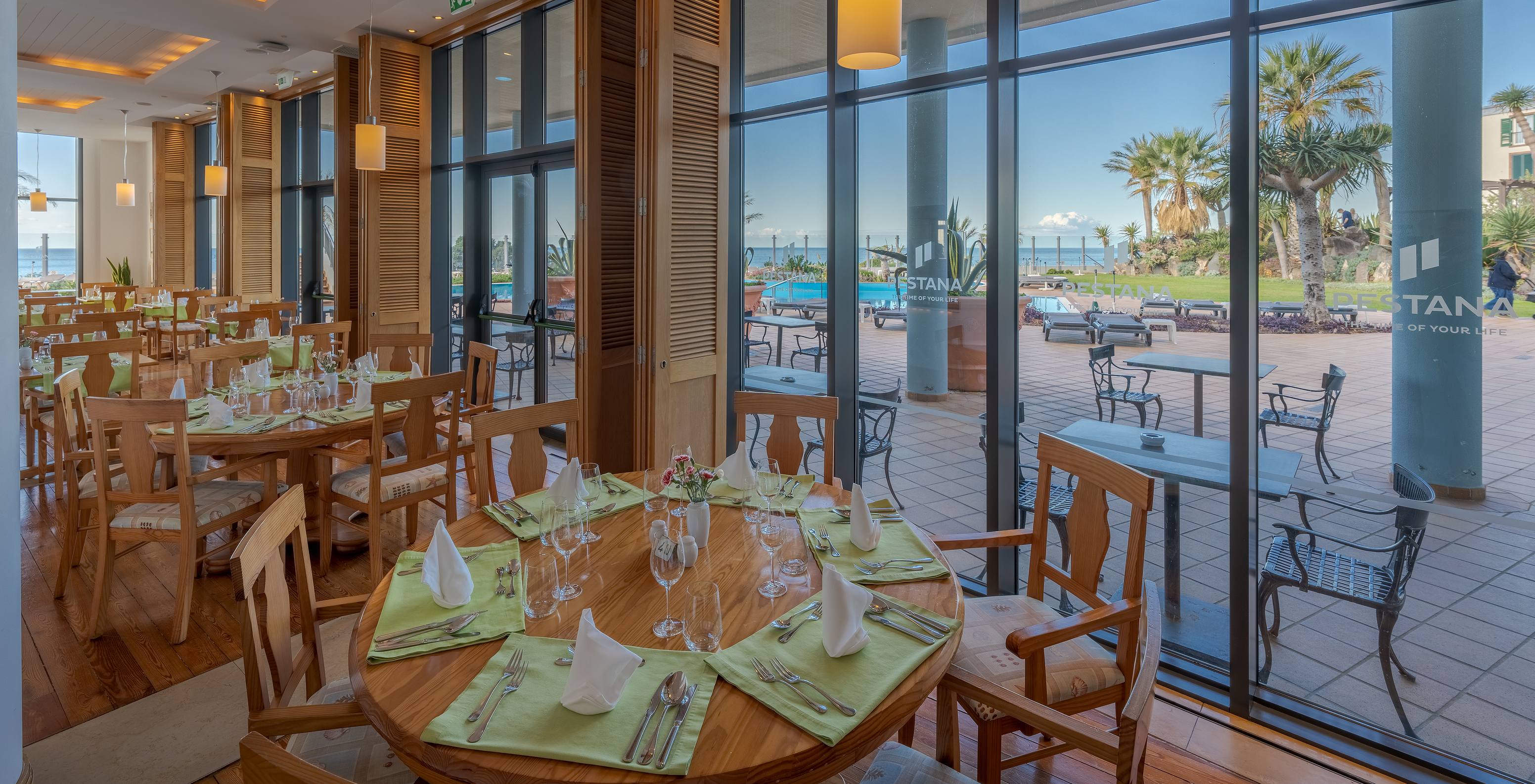 O restaurante Cabo Girão, do Hotel 5 Estrelas no Funchal, na Madeira, tem uma sala com mesas com talheres e vista para o mar