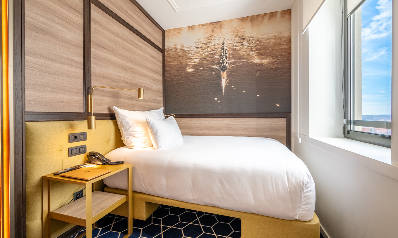 O Small Double Room do Pestana CR7 Gran Vía Madrid tem uma cama de frente para a janela e um quadro na parede de uma equipa de remo