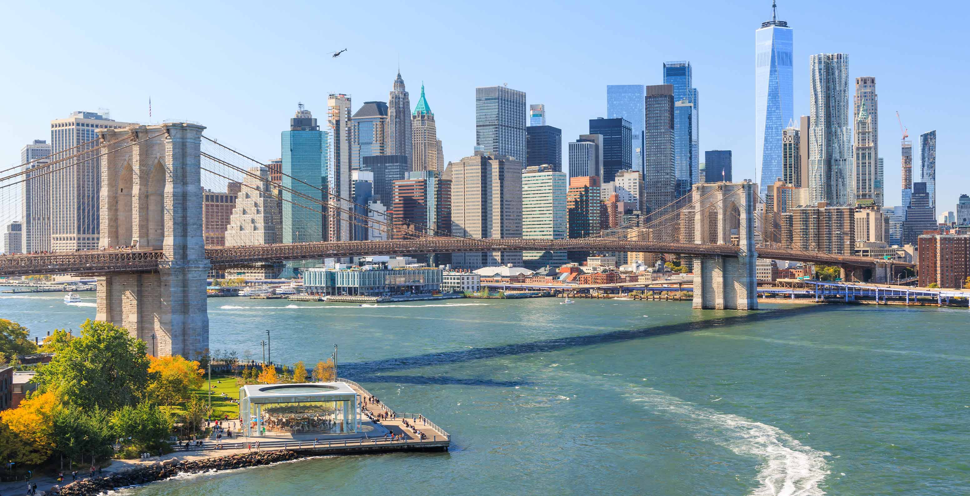 Vista panorâmica da Ponte do Brooklyn, sobre o East River, com o horizonte da cidade de Manhattan no fundo da imagem